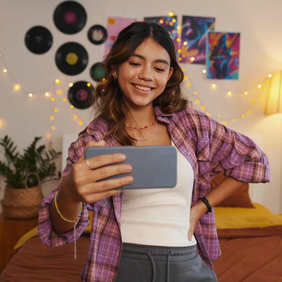 Person smiling while scrolling through a phone, representing positive mental health content and resources for anxiety therapy in Orlando.