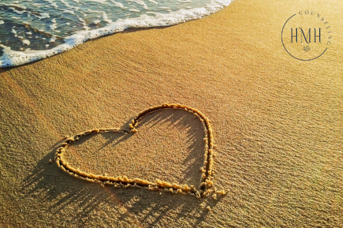 heart drawn in sand at beach.