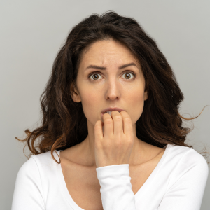 An image showing a visibly anxious woman, her hands held tightly together, symbolizing the stress from lack of personal boundaries, used in a blog post discussing the importance of setting boundaries for mental wellbeing.